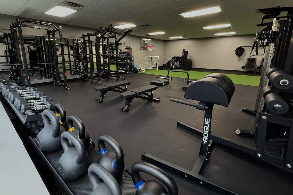 The Centennial clinic gym, with turf, squat racks and a basketball hoop