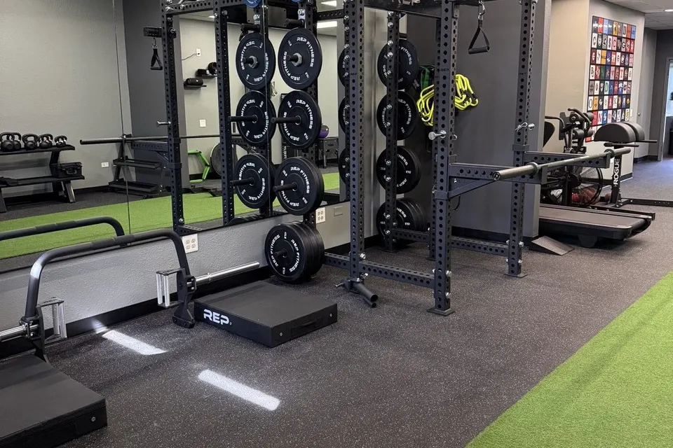 The Highlands Ranch clinic, with a turf lane and a row of squat racks