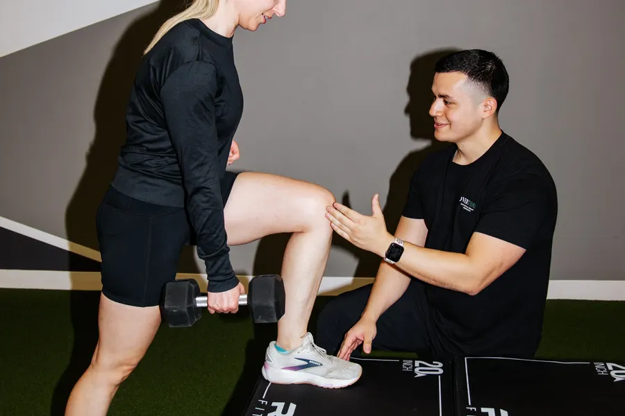 Dr. Edward Benitez checking a runner's knee during a step-up exercise
